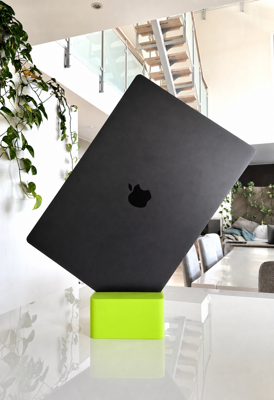 Cubistand in lime holding a closed black MacBook Pro
