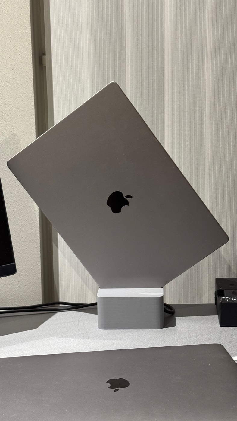 Cubistand in light gray holding a closed MacBook Pro